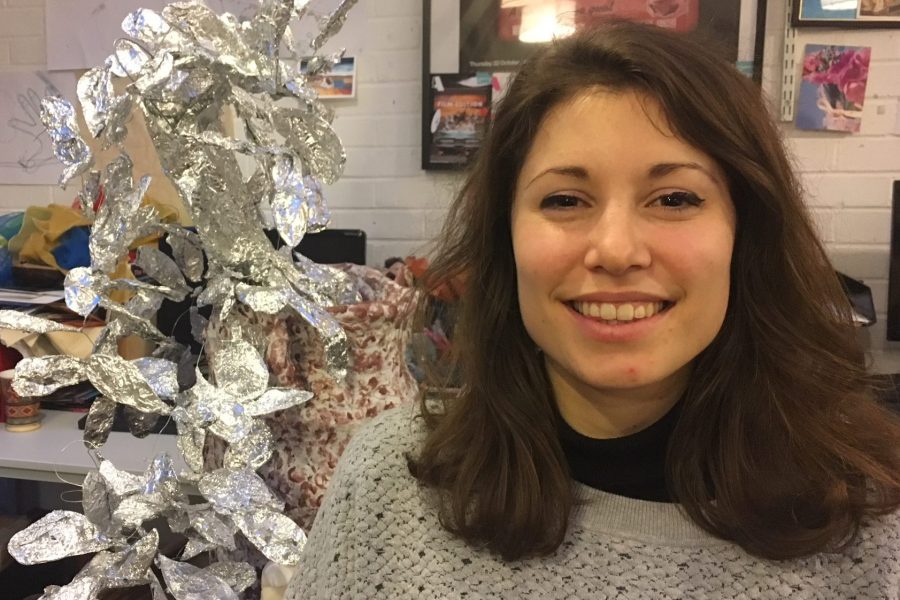 portrait of sarah smiling with silver sculpture