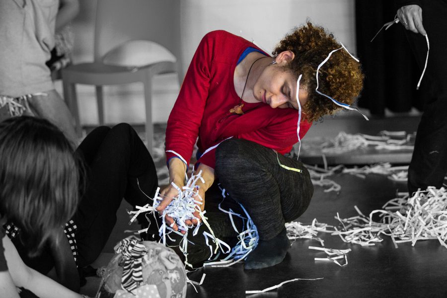 woman crouching touches shredded paper