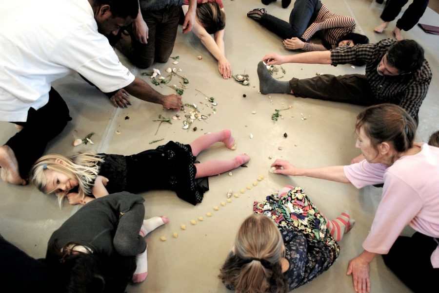 children and adults on the floor playing with pasta shapes and shells