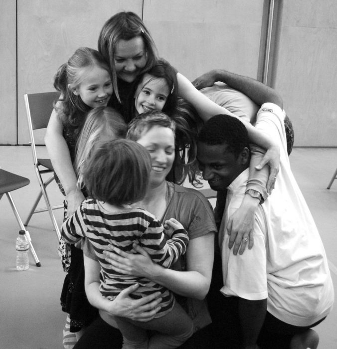 young children in a group hug smiling