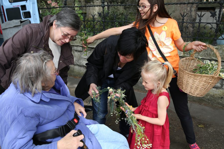 Young girl hnading plant sculpture to older lady