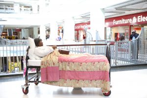 Actor in bed in shopping centre