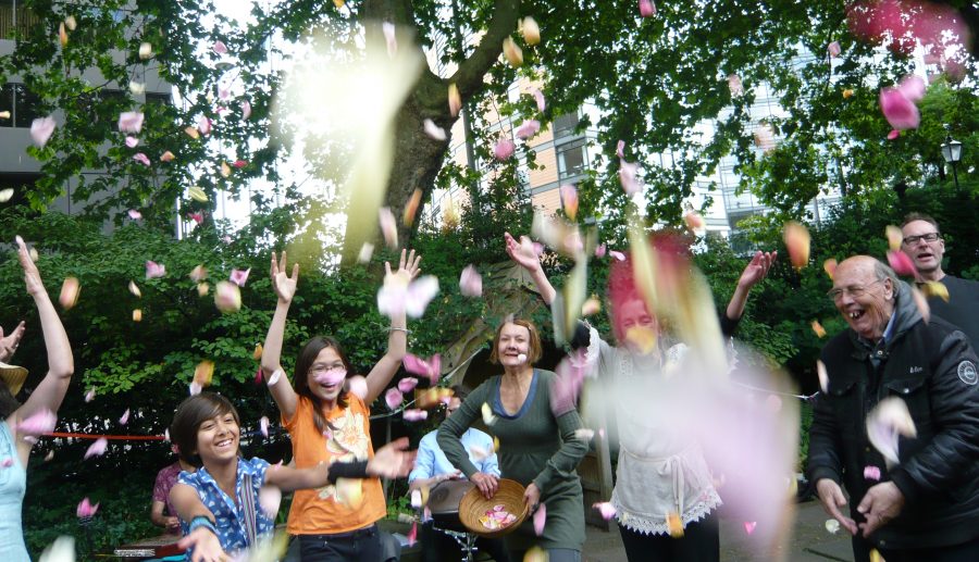 people in a garden jumping up throwing confetti