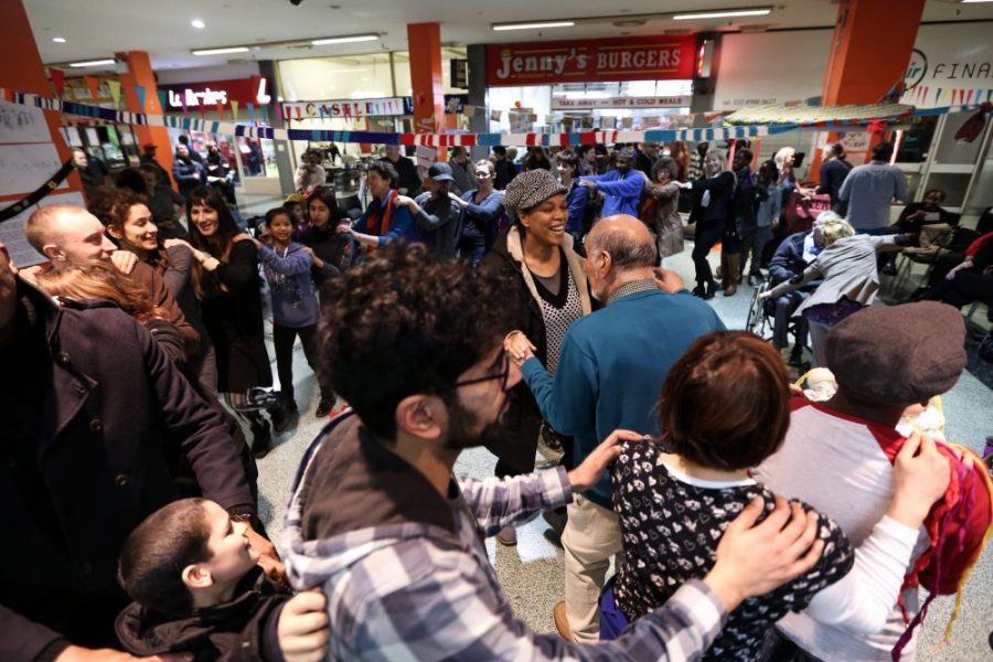 many people holding shoulders walking in a line