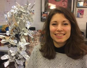 portrait of sarah smiling with silver sculpture