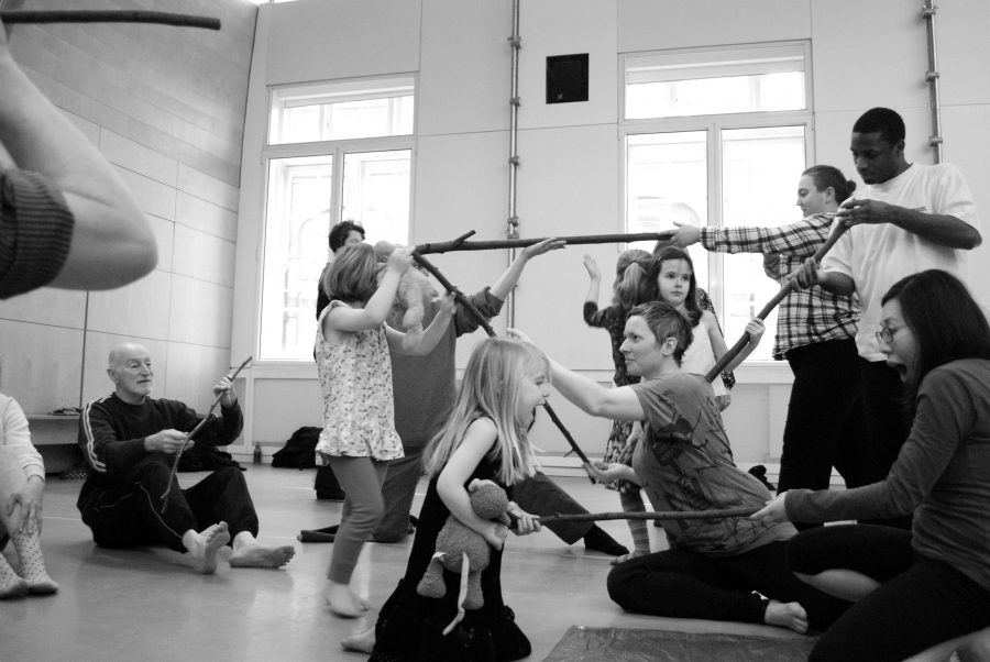 participants moving on the floor with wooden sticks