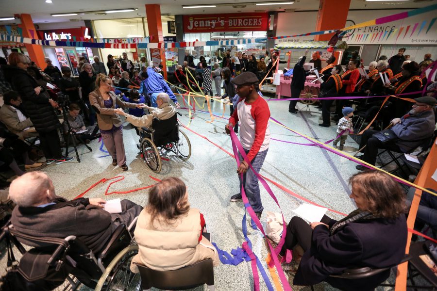 Many people in shopping centre with streamers around them