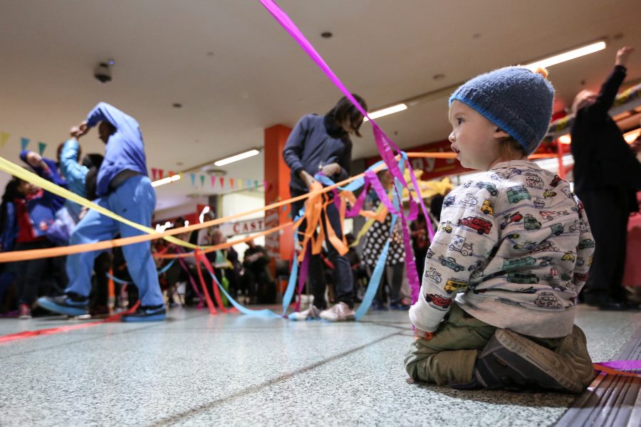 Young child on floor looking in awe at streamers