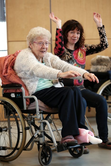 woman in wheelchair reaching arms out