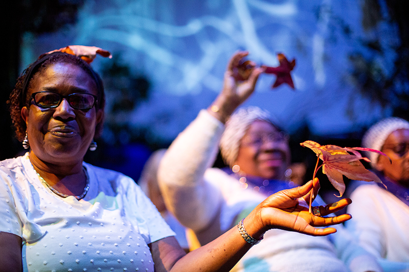 two women holding tree leaves