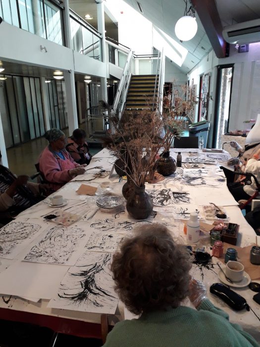 people painting around a table