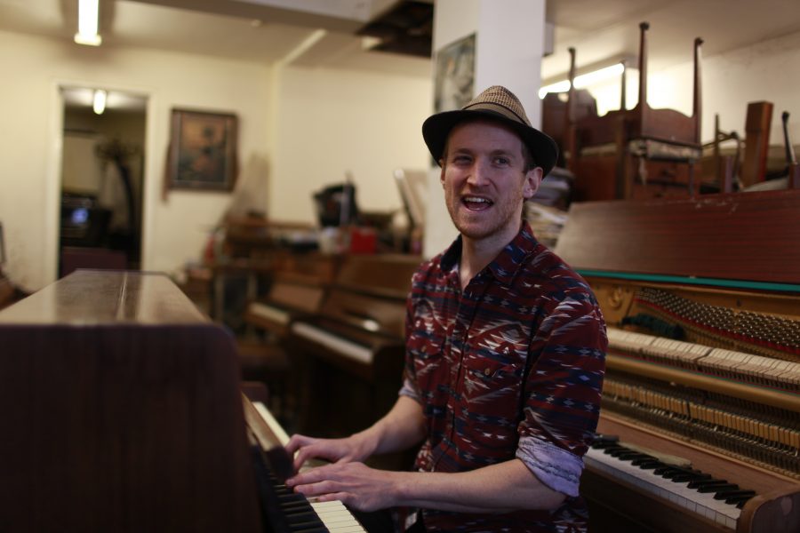 Man playing piano in a hat