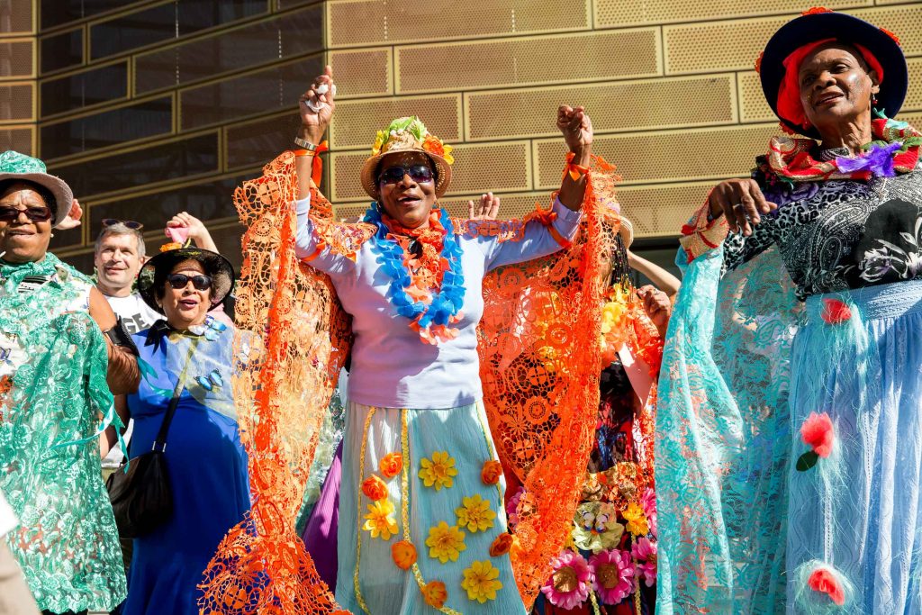 people dressed in colourful clothes dancing in street