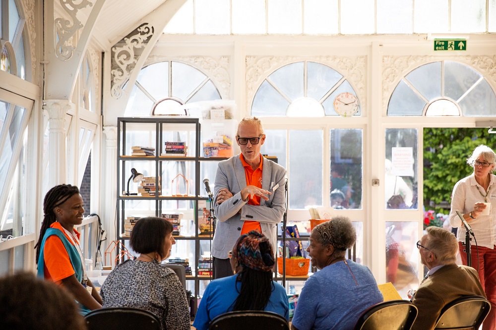 man talking to people in theatrical care home