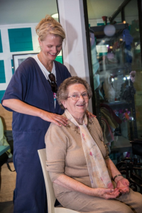 woman massages elderly womans shoulders