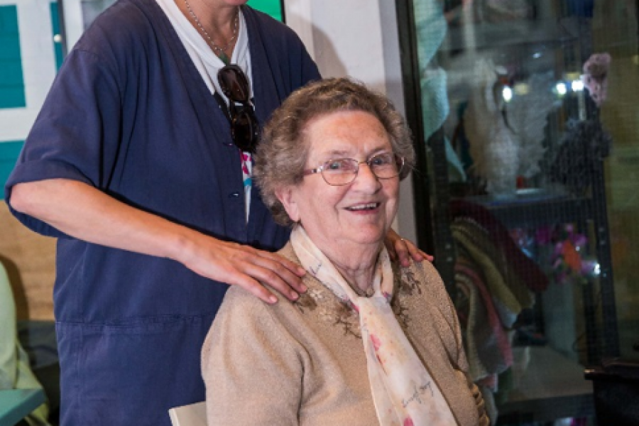 woman massages elderly womans shoulders