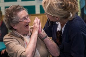 Older woman laughing with a carer