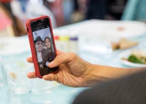 hand holding phone which has image of a man and woman on it