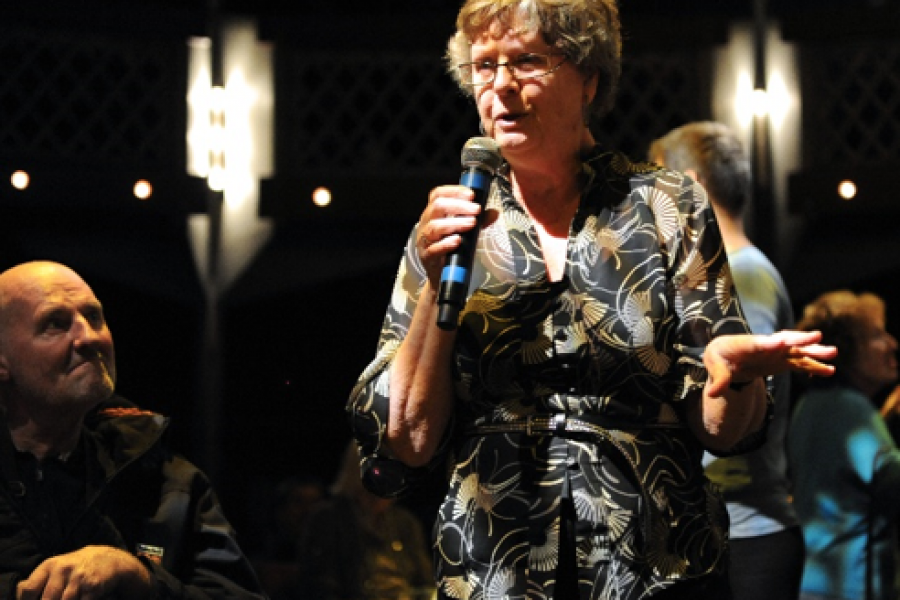 older woman holding microphone singing