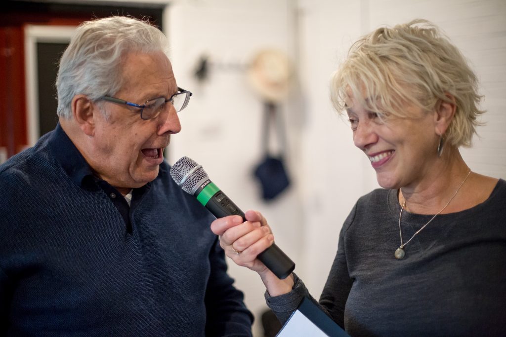 Woman holding a microphone with man talking