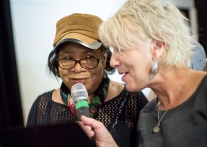 women singing with a microphone and smiling