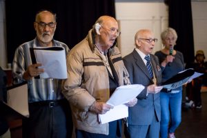 four men singing together 