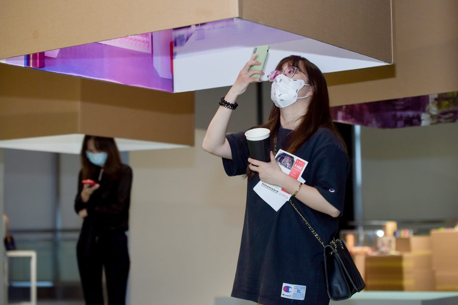 Chinese woman wearing facemask looking at an exhibition