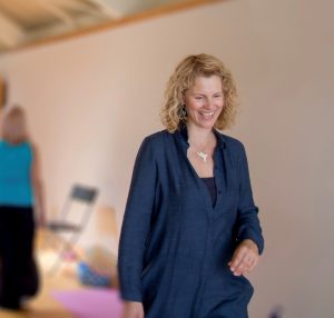 picture of the artist smiling but looking down while walking