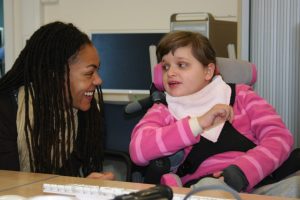 black woman talking to girl in a wheelchair