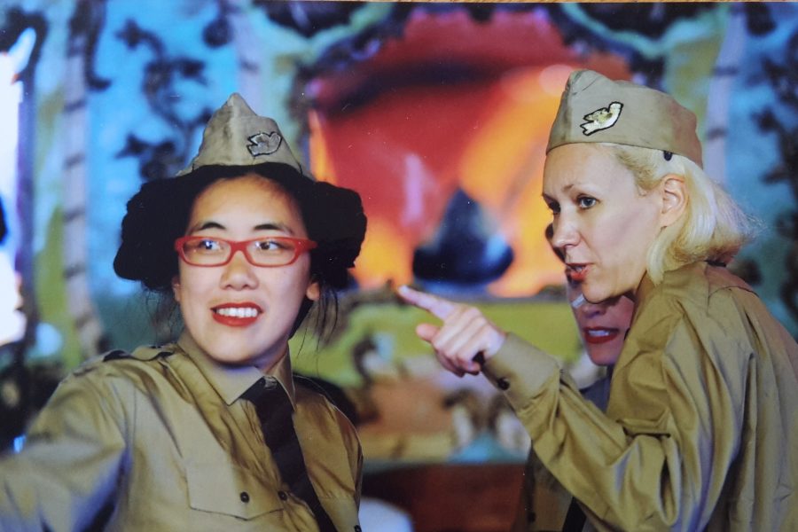 two women dressed in military uniforms outside a tent