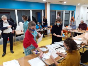 A group of people carefully packing art supplies in envelopes