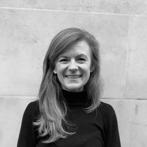 A black and white image of a woman with long hair smiling