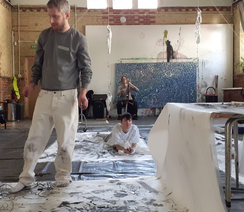 A person standing on a large piece of paper covered in scribbles.