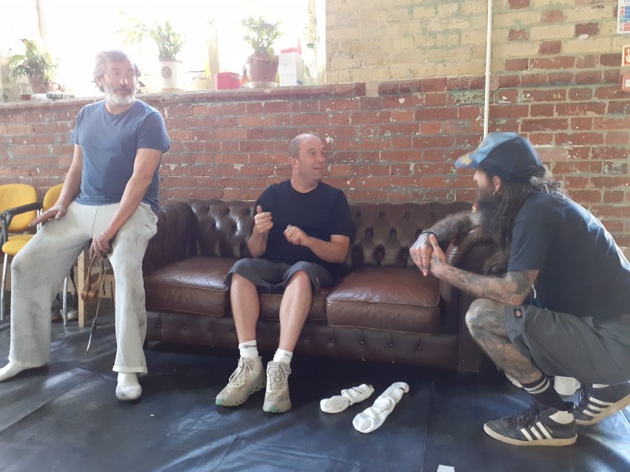 Three people sitting on a sofa.